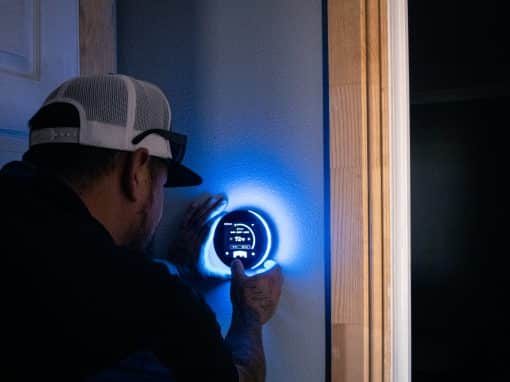 Technician adjusting a smart thermostat